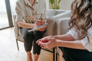 therapist talking with concerned patient in office setting about relapse prevention therapy