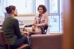 femlae behavioral health specialist discussing the benefits of life skills training with a female client in a professional office setting.